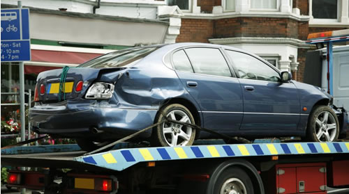 Accident damaged car on trailer